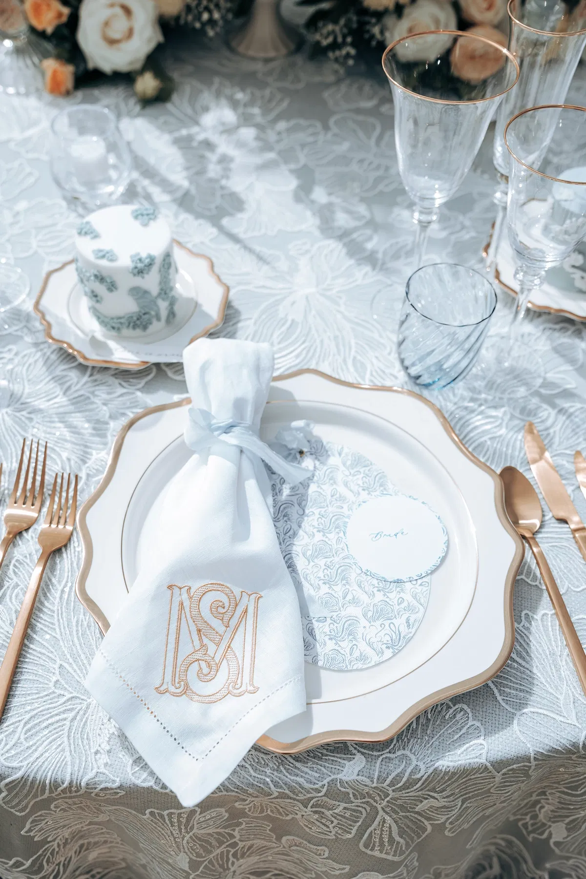 gedekte tafel voor bruidsdiner met gepersonaliseerde servetten en luxe servies.