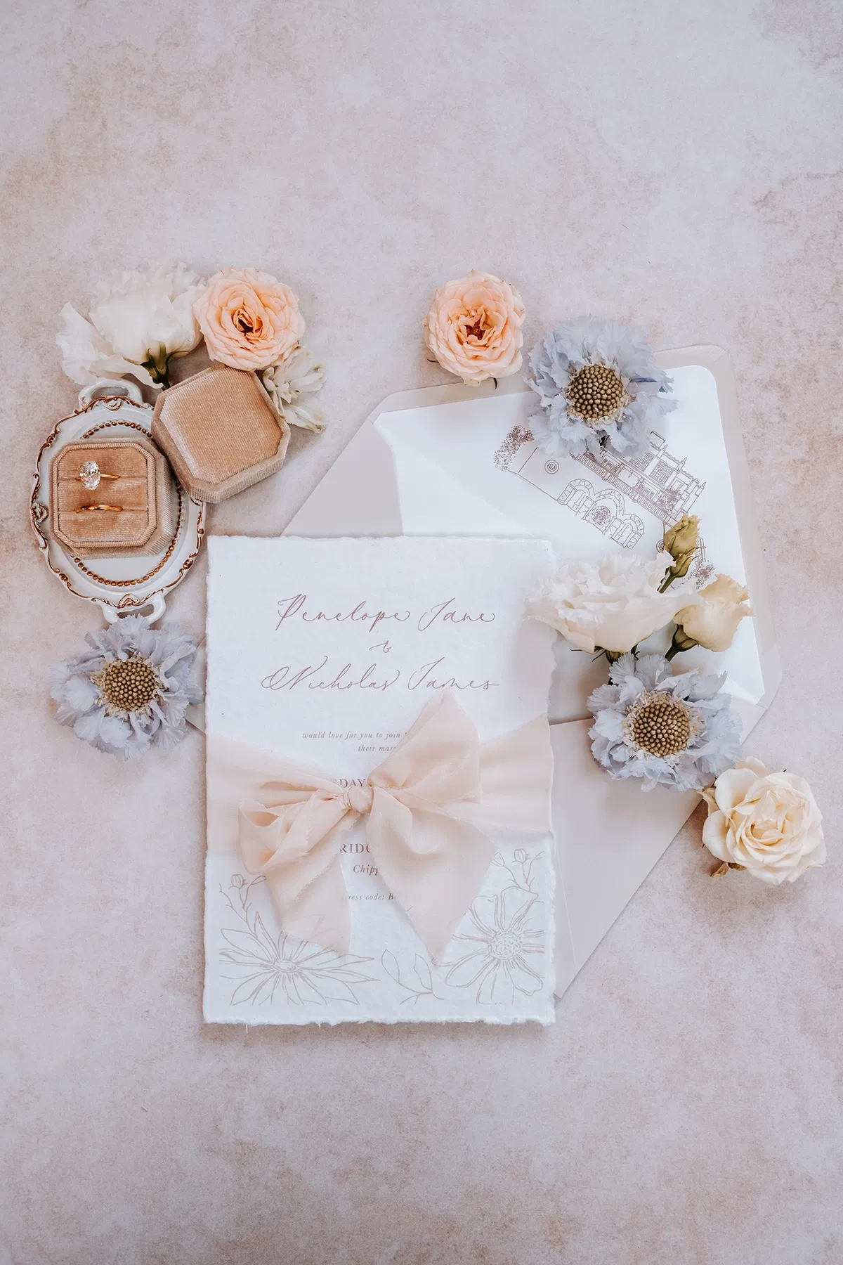 chic pastelkleurig papeterie voor bruiloft. met bloemen en trouwring met grote diamant.