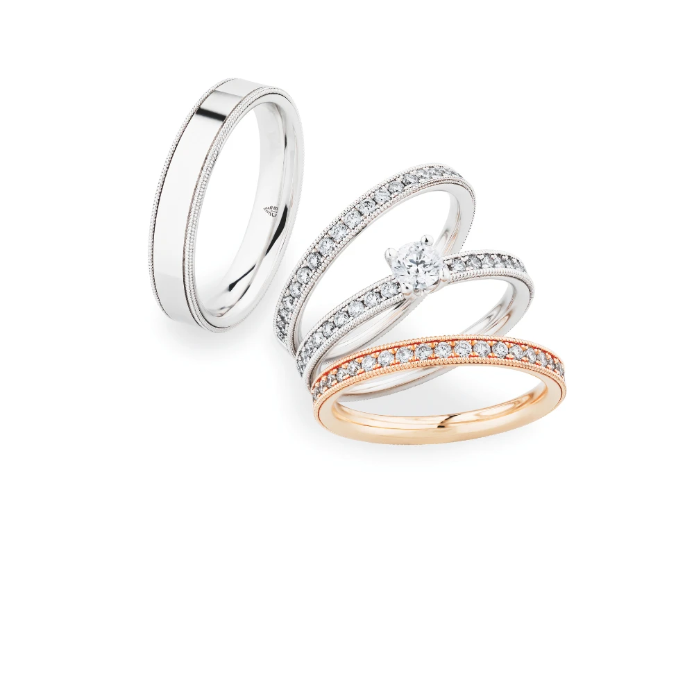 Een elegante collectie trouwringen, waaronder een witgouden ring met subtiele details, een schitterende diamanten solitair-ring en een roségouden ring met fonkelende diamanten.