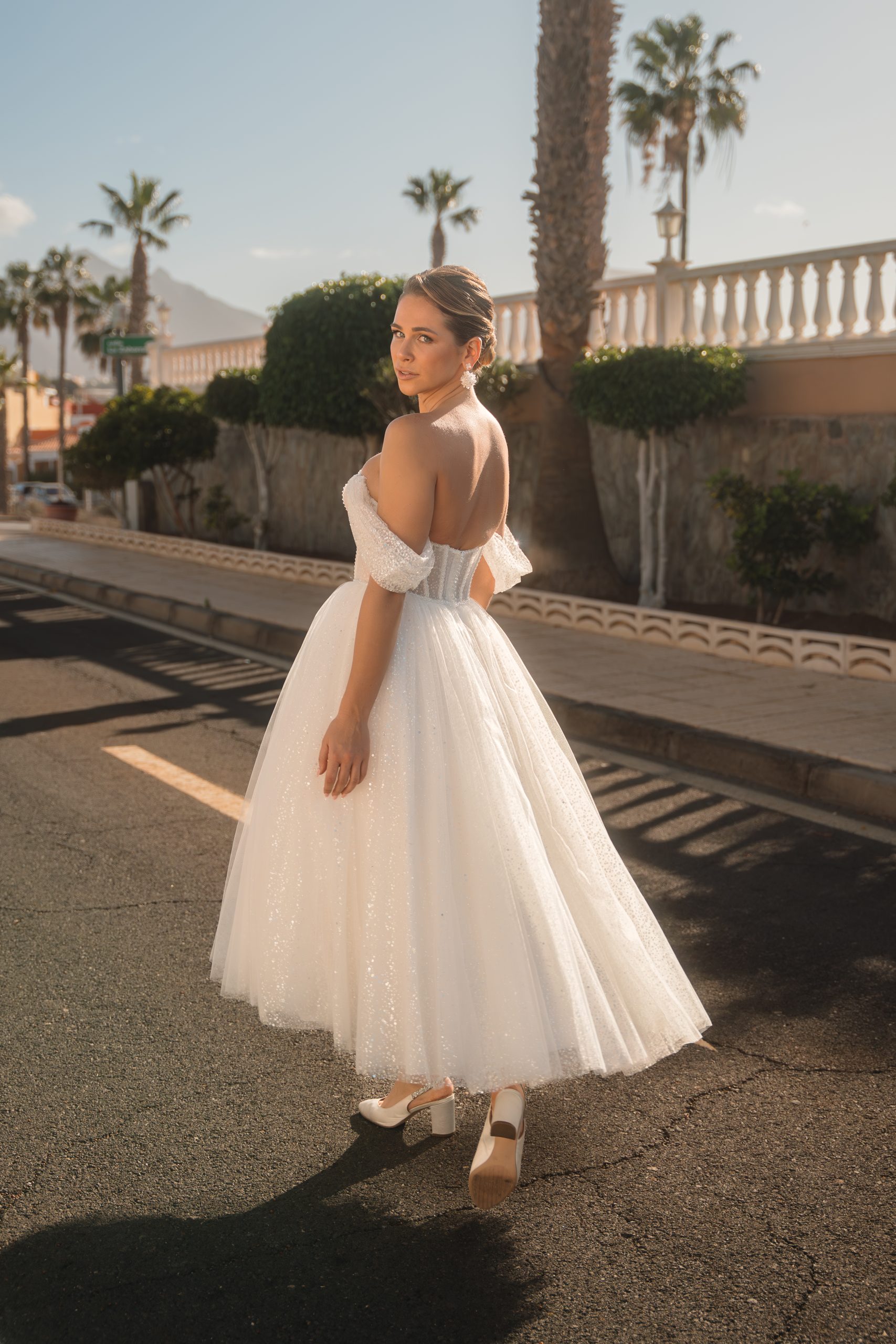 Korte witte trouwjurk met een rok van tule. Off shoulders bandjes met een strakke top.