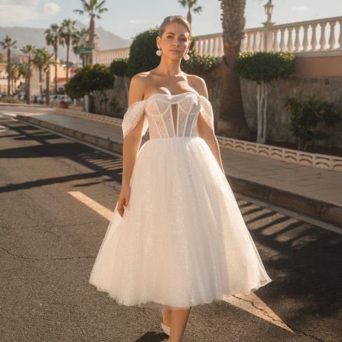 Korte witte trouwjurk met een rok van tule. Off shoulders bandjes met een strakke top.