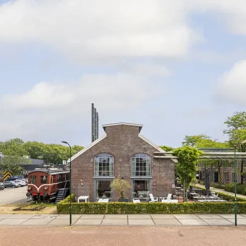 Industriële trouwlocatie Centraal Ketelhuis in Amersfoort met karakteristiek bakstenen gebouw en nostalgische trein – unieke plek voor bruiloften met historie.
