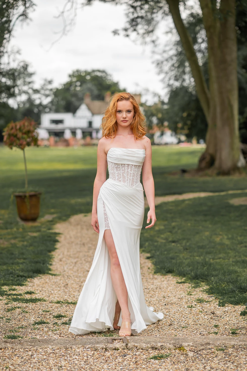 Moderne strapless trouwjurk met hoge split en kanten lijfje – eigentijdse bruidsmode voor zelfverzekerde bruiden met een sexy touch.