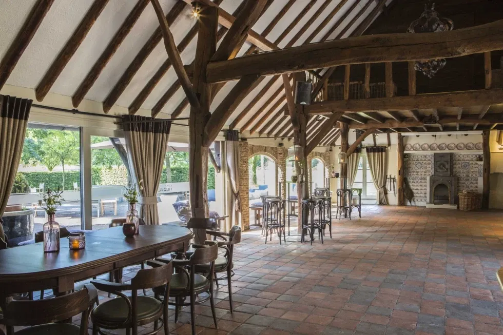 Sfeervolle binnenruimte van Hoeve Sparrendam met houten balken, tegelvloer en landelijke charme – rustieke trouwlocatie met authentiek karakter.
