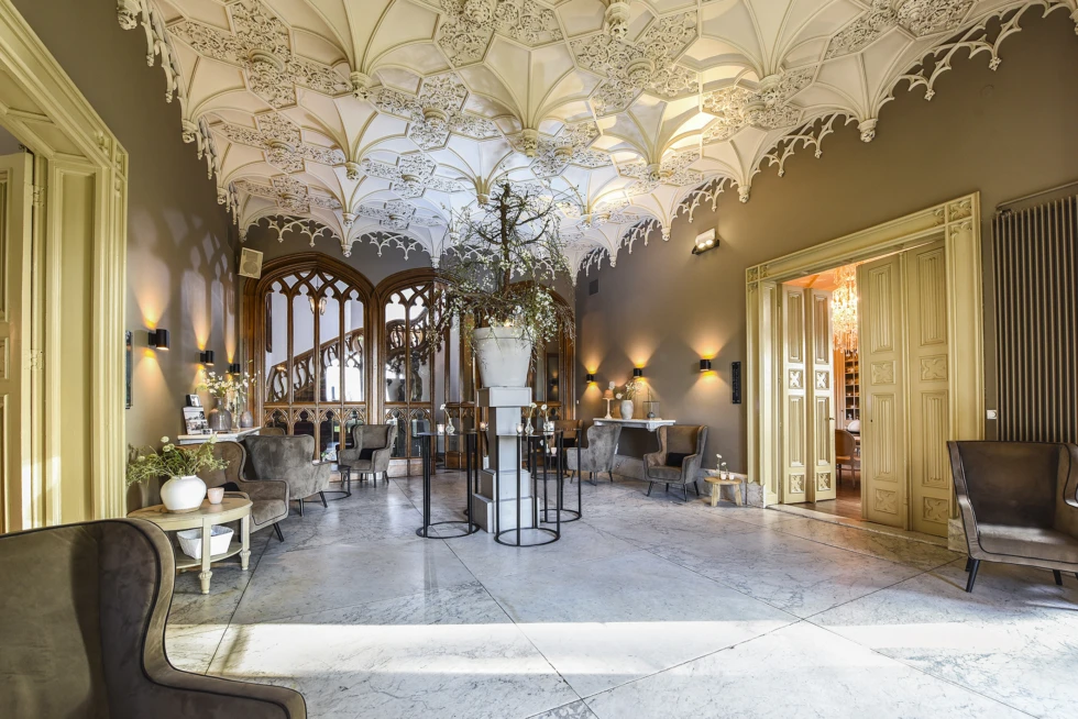 Sfeervolle ontvangstruimte in Kasteel De Schaffelaar met rijk gedecoreerd plafond en klassieke details.