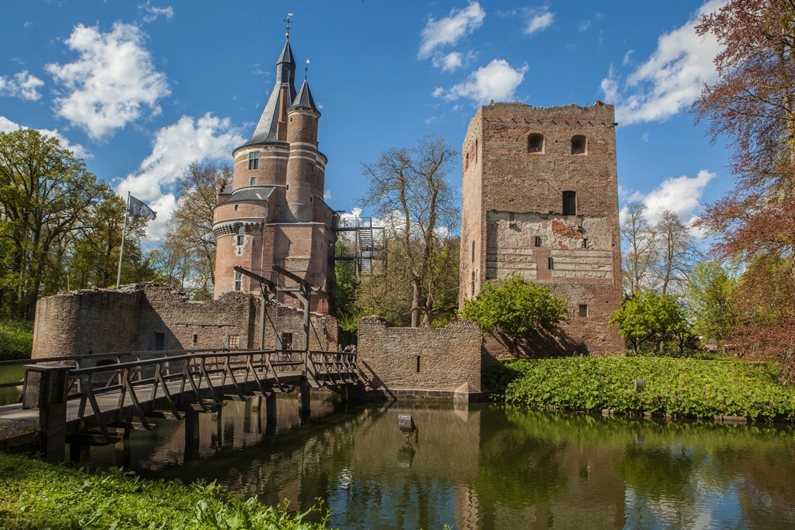 Buitenaanzicht van Kasteel Duurstede met torens, ruïne en ophaalbrug over de gracht.