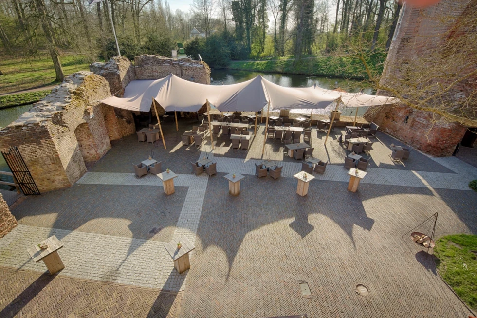Buitenplaats van Kasteel Duurstede met stretchtent en historische ruïnemuren aan het water.