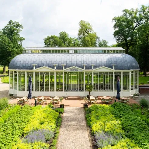 Trouwlocatie Oranjerie De Schaffelaar met glazen gevel, elegante architectuur en omliggende kasteeltuin – romantische setting voor een stijlvolle bruiloft.