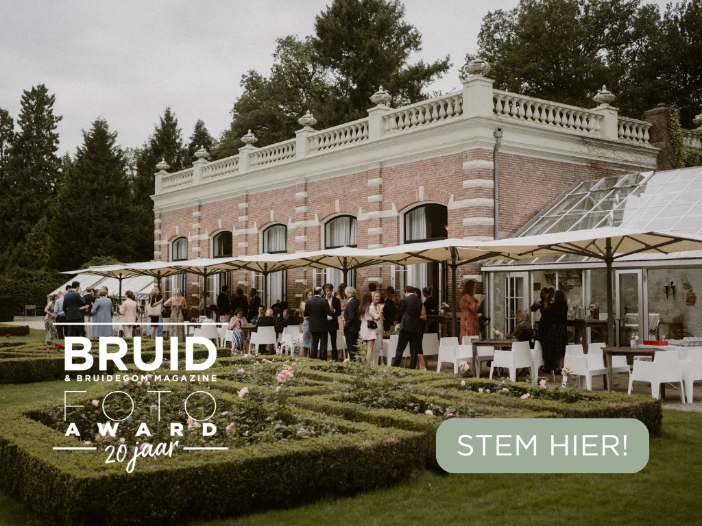 Bruiloftsreceptie in de tuin van een klassiek landhuis met gasten onder parasols, met op de voorgrond een logo voor de 'Bruid & Bruidegom Magazine Foto Award 20 jaar' en een groene knop met de tekst 'STEM HIER!