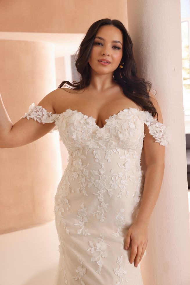 Detail trouwjurk Amy met off-shoulder bloemenkant, romantische ivoorkleurige stof en verfijnde bruidsdetails – Azuree Bridal.