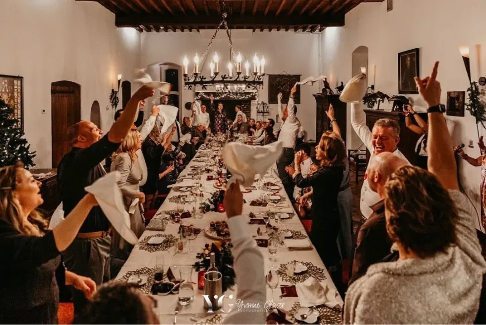 Groep mensen dat aan een hele lange tafel aan het eten zijn