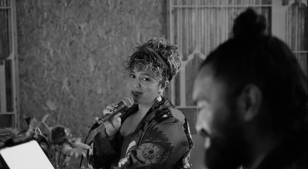 Zwart-wit foto van een vrouw die een microfoon in haar handen heeft