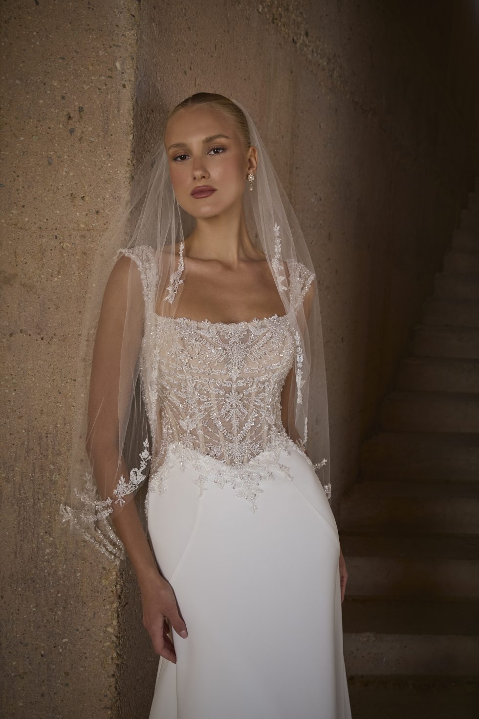 Bruid met een aansluitende trouwjurk met een doorschijnend bovenlijfje met glitters.