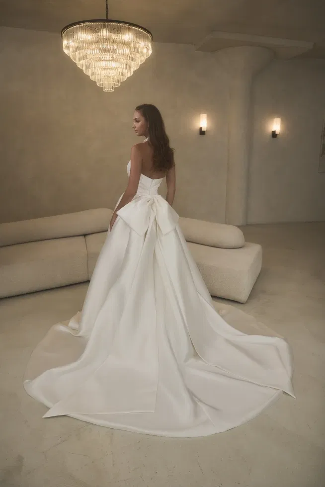Ivoorkleurige trouwjurk van Casablana met een grote strik achterop.